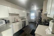kitchen with white cabinets, light countertops, and a sink