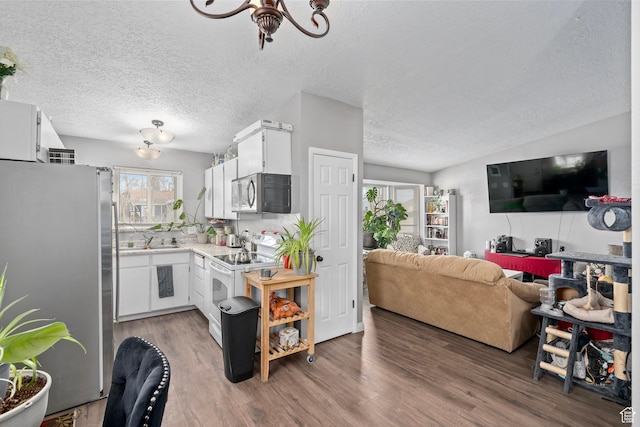 2670 S Melville Dr, Magna, UT 84044 - kitchen featuring light countertops, white cabinets, wood finished floors, and stainless steel appliances