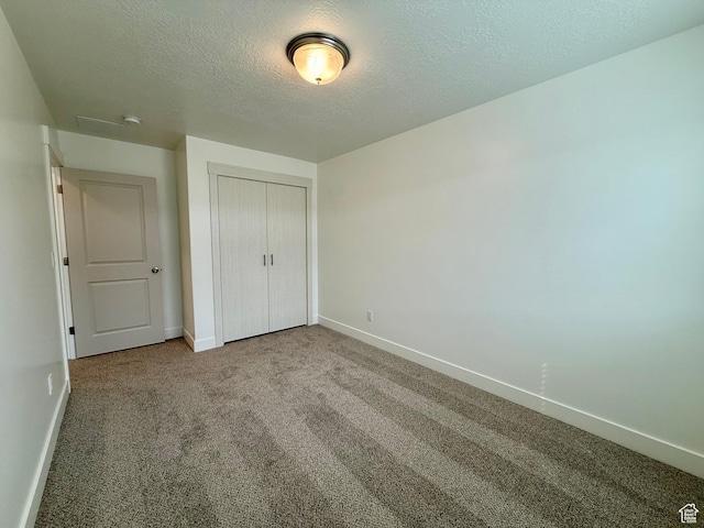 3362 S 1010 W, Nibley, UT 84321 - unfurnished bedroom with a closet, baseboards, carpet, and a textured ceiling