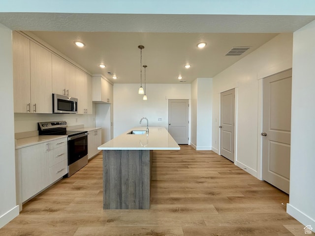 3362 S 1010 W, Nibley, UT 84321 - kitchen with visible vents, light wood-style flooring, a sink, appliances with stainless steel finishes, and light countertops