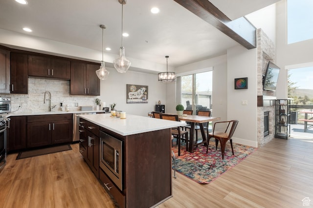 8077 Courtyard Loop Unit 11, Park City, UT 84098 - kitchen featuring stainless steel microwave, light wood-style floors, light countertops, dark brown cabinetry, and recessed lighting
