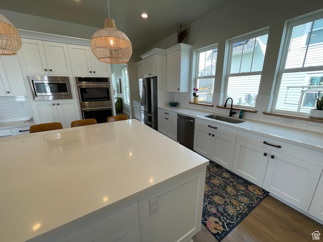 10887 S Lamond Dr, South Jordan, UT 84009 - kitchen featuring a sink, decorative backsplash, black appliances, white cabinets, and light countertops