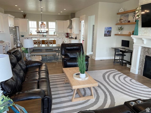 10887 S Lamond Dr, South Jordan, UT 84009 - living area with a tiled fireplace, recessed lighting, dark wood-type flooring, and baseboards