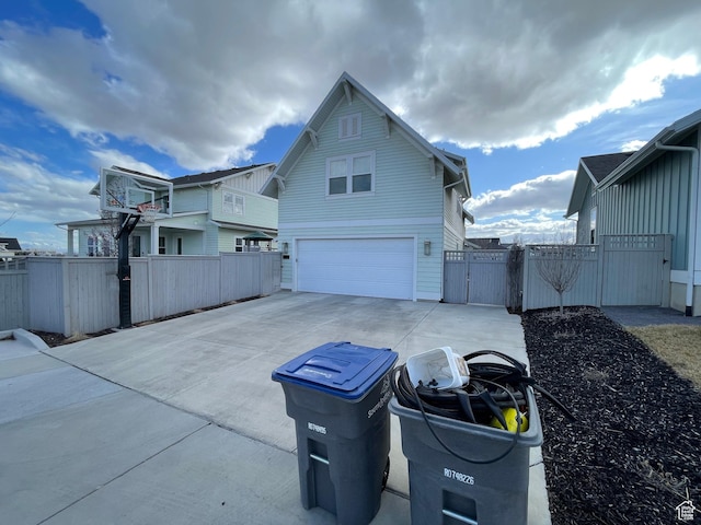 10887 S Lamond Dr, South Jordan, UT 84009 - view of property exterior featuring fence, concrete driveway, an attached garage, and a gate