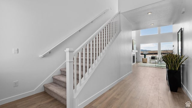stairs with baseboards and wood finished floors