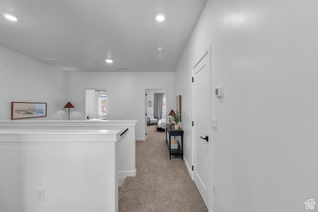 corridor with baseboards, recessed lighting, visible vents, and light carpet