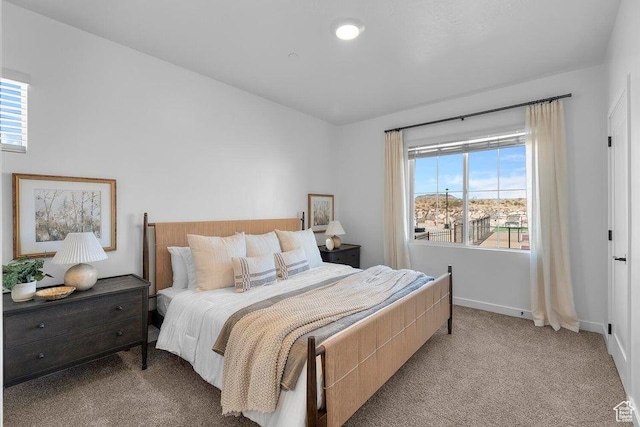 carpeted bedroom with baseboards and multiple windows