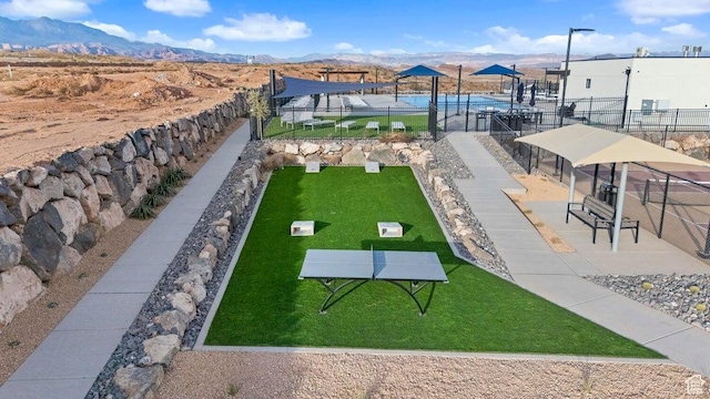 view of community featuring fence and a mountain view