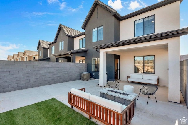 rear view of property featuring an outdoor living space, fence, a patio, and stucco siding