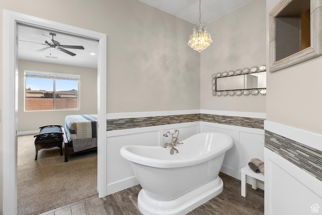 2691 S 3970 W, Hurricane, UT 84737 - bathroom with wainscoting, ceiling fan with notable chandelier, a freestanding tub, wood finished floors, and a decorative wall