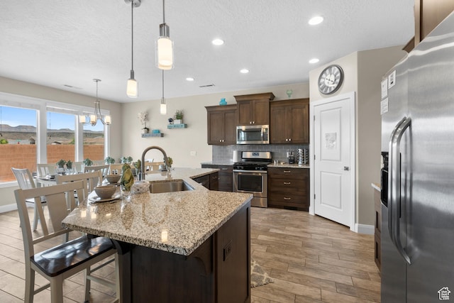 2691 S 3970 W, Hurricane, UT 84737 - kitchen featuring tasteful backsplash, light wood finished floors, appliances with stainless steel finishes, a kitchen breakfast bar, and a sink