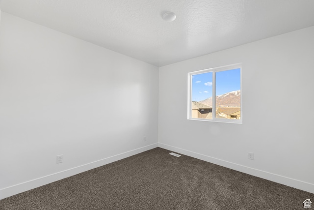 1667 S Marigold Way Unit 230E, Santaquin, UT 84655 - spare room with baseboards, visible vents, dark colored carpet, and a textured ceiling