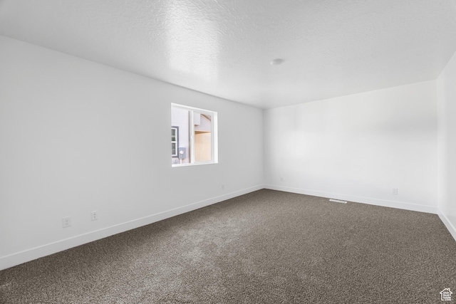 1667 S Marigold Way Unit 230E, Santaquin, UT 84655 - spare room featuring baseboards, a textured ceiling, and dark colored carpet