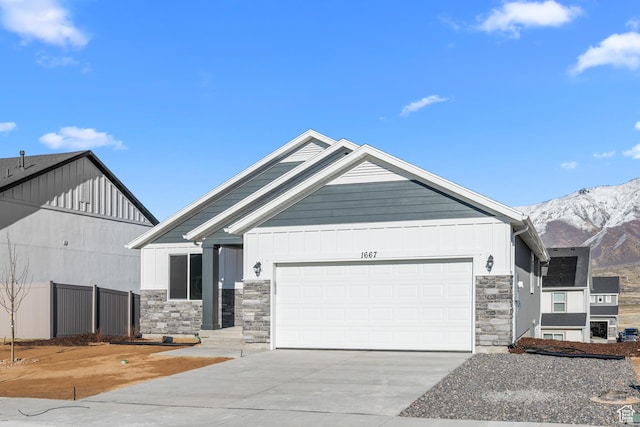 1667 S Marigold Way Unit 230E, Santaquin, UT 84655 - view of front of home with fence, an attached garage, stone siding, driveway, and a mountain view