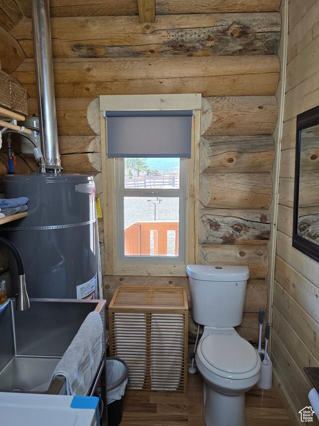 365 W Sleeping Rainbow Dr, Torrey, UT 84775 - bathroom with rustic walls, wood finished floors, toilet, and secured water heater