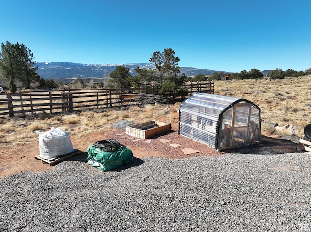 365 W Sleeping Rainbow Dr, Torrey, UT 84775 - view of yard with a greenhouse, an outbuilding, fence, and a mountain view
