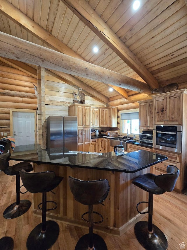365 W Sleeping Rainbow Dr, Torrey, UT 84775 - kitchen with a breakfast bar area, wood finished floors, rustic walls, and appliances with stainless steel finishes