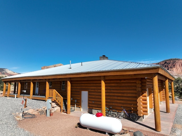 365 W Sleeping Rainbow Dr, Torrey, UT 84775 - rear view of house with metal roof, a chimney, a mountain view, and log exterior