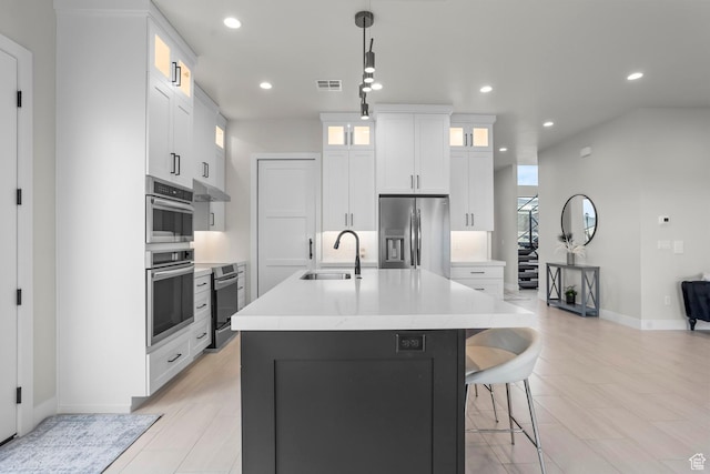 1036 E Fremont St, Washington, UT 84780 - kitchen featuring visible vents, a kitchen island with sink, a sink, under cabinet range hood, and appliances with stainless steel finishes