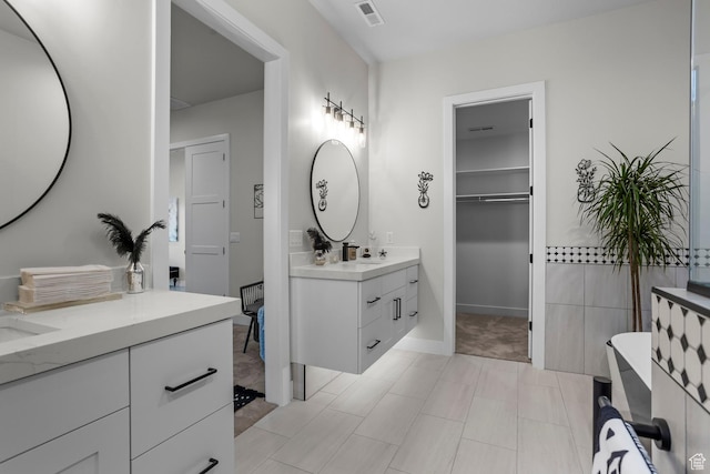 1036 E Fremont St, Washington, UT 84780 - bathroom featuring a walk in closet, two vanities, visible vents, and a sink