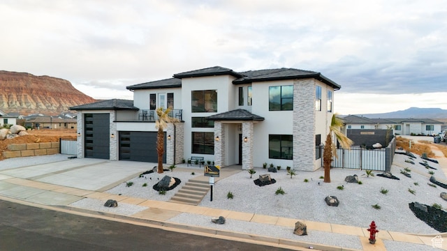 1036 E Fremont St, Washington, UT 84780 - view of front of house featuring stone siding, a mountain view, driveway, and fence
