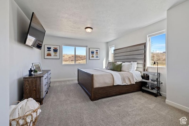 carpeted bedroom with baseboards and a textured ceiling