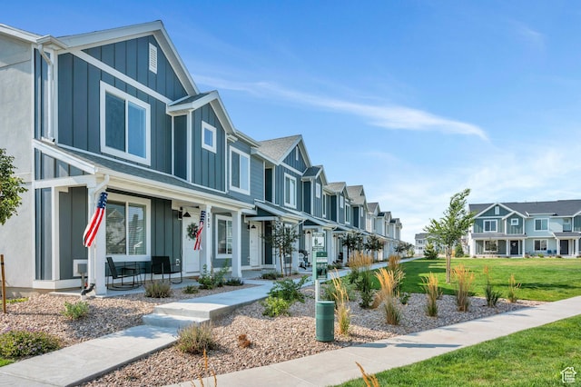 388 N Regatta Ln, Saratoga Springs, UT 84045 - view of front of home featuring a porch, a residential view, board and batten siding, and a front lawn