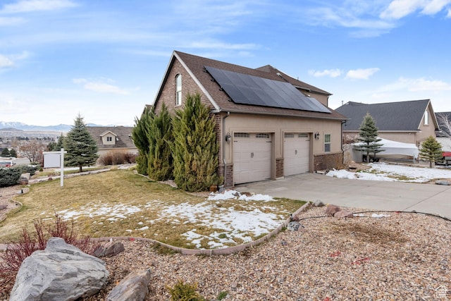 1035 E 300 S, Santaquin, UT 84655 - view of side of property featuring roof mounted solar panels, concrete driveway, brick siding, stucco siding, and a shingled roof