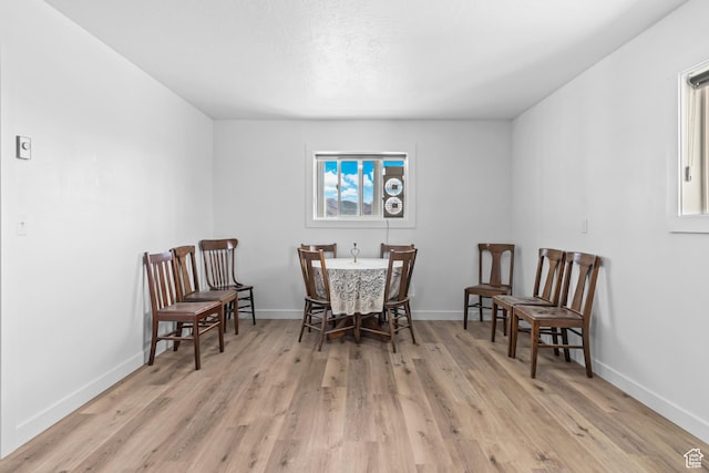 dining room with baseboards and light wood finished floors
