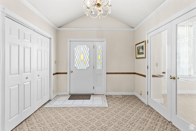 carpeted foyer with a wealth of natural light, baseboards, lofted ceiling, and an inviting chandelier