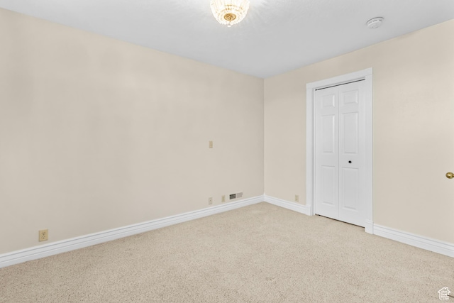 unfurnished room featuring light carpet, visible vents, and baseboards