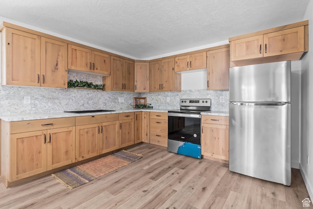 kitchen with decorative backsplash, a textured ceiling, appliances with stainless steel finishes, and light wood-style flooring