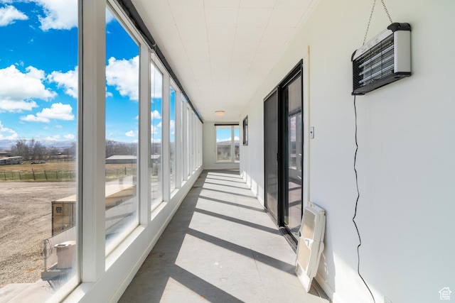 unfurnished sunroom with a wall unit AC and expansive windows