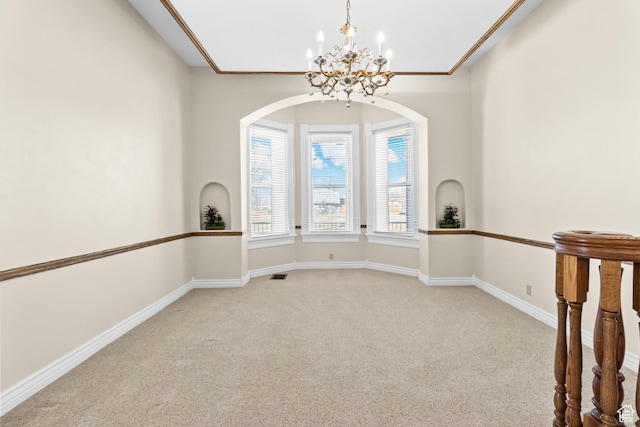 spare room featuring a chandelier, visible vents, baseboards, and carpet floors