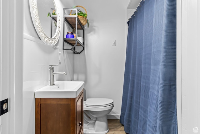 bathroom featuring a shower with curtain, toilet, and vanity