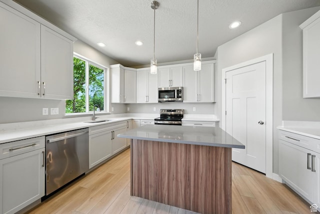 552 E 41st St, South Ogden, UT 84403 - kitchen featuring stainless steel appliances, recessed lighting, light wood-style floors, a textured ceiling, and white cabinetry