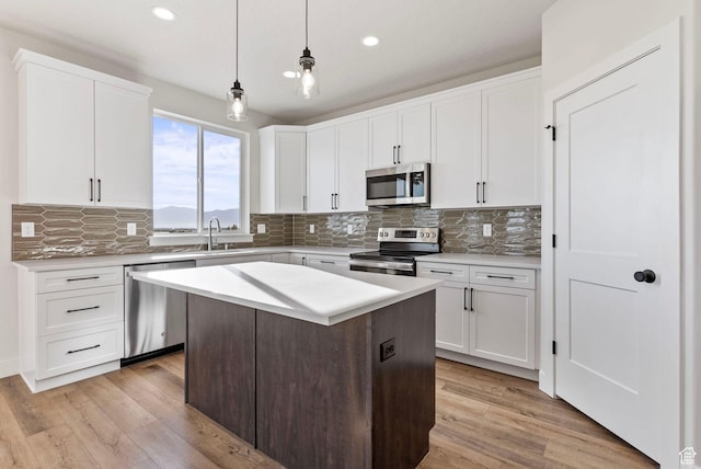 552 41st St, South Ogden, UT 84403 - kitchen with stainless steel appliances, tasteful backsplash, a sink, and light wood-style floors