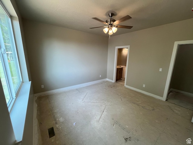 552 41st St, South Ogden, UT 84403 - unfurnished bedroom featuring a textured ceiling, baseboards, ensuite bathroom, and a ceiling fan