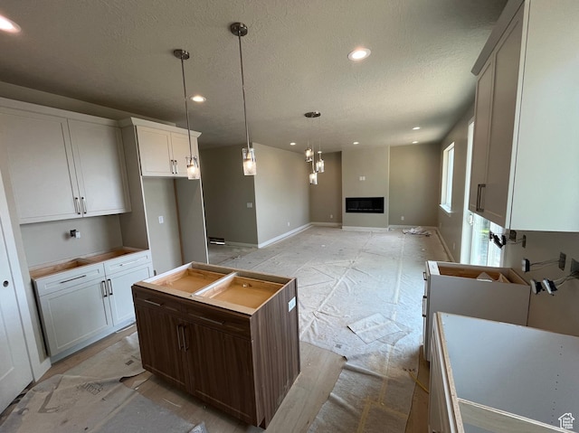 552 41st St, South Ogden, UT 84403 - kitchen featuring a textured ceiling, recessed lighting, a fireplace, baseboards, and hanging light fixtures