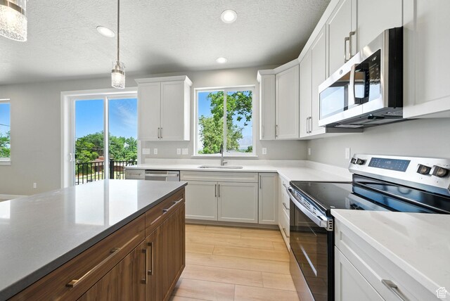 552 E 41st St, South Ogden, UT 84403 - kitchen with appliances with stainless steel finishes, recessed lighting, white cabinetry, a textured ceiling, and hanging light fixtures
