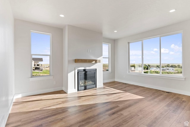552 41st St, South Ogden, UT 84403 - unfurnished living room with a glass covered fireplace, recessed lighting, baseboards, wood finished floors, and visible vents