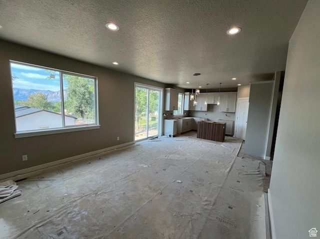 552 41st St, South Ogden, UT 84403 - unfurnished living room featuring a textured ceiling, recessed lighting, and baseboards