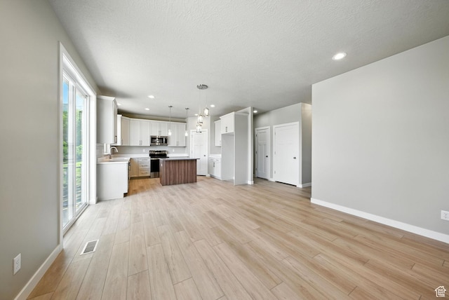 552 E 41st St, South Ogden, UT 84403 - unfurnished living room with light wood finished floors, recessed lighting, and a textured ceiling