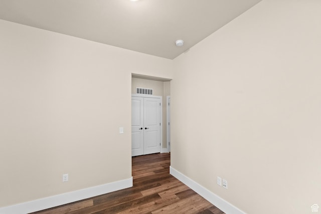 empty room featuring visible vents, baseboards, and wood finished floors