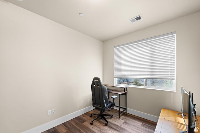 office area featuring visible vents, baseboards, and wood finished floors