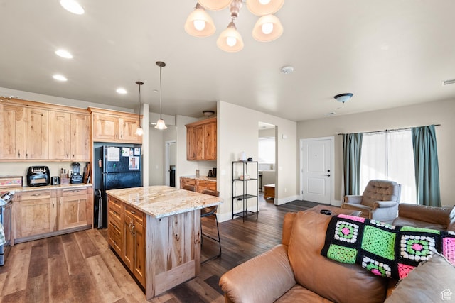 kitchen with a kitchen breakfast bar, plenty of natural light, open floor plan, and freestanding refrigerator