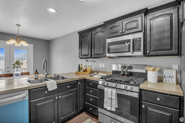 162 S 500 W, Tremonton, UT 84337 - kitchen featuring a sink, wood finished floors, stainless steel appliances, an inviting chandelier, and light countertops
