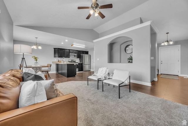 162 S 500 W, Tremonton, UT 84337 - living room featuring dark wood finished floors, vaulted ceiling, ceiling fan with notable chandelier, and baseboards