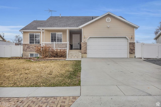 ranch-style home featuring fence, a porch, concrete driveway, a front lawn, and a garage