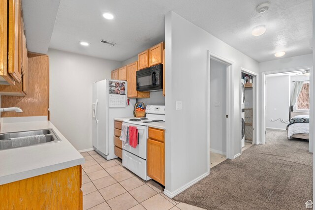 137 W 600 N Unit 205, Tooele, UT 84074 - kitchen with visible vents, light carpet, a sink, white appliances, and light countertops